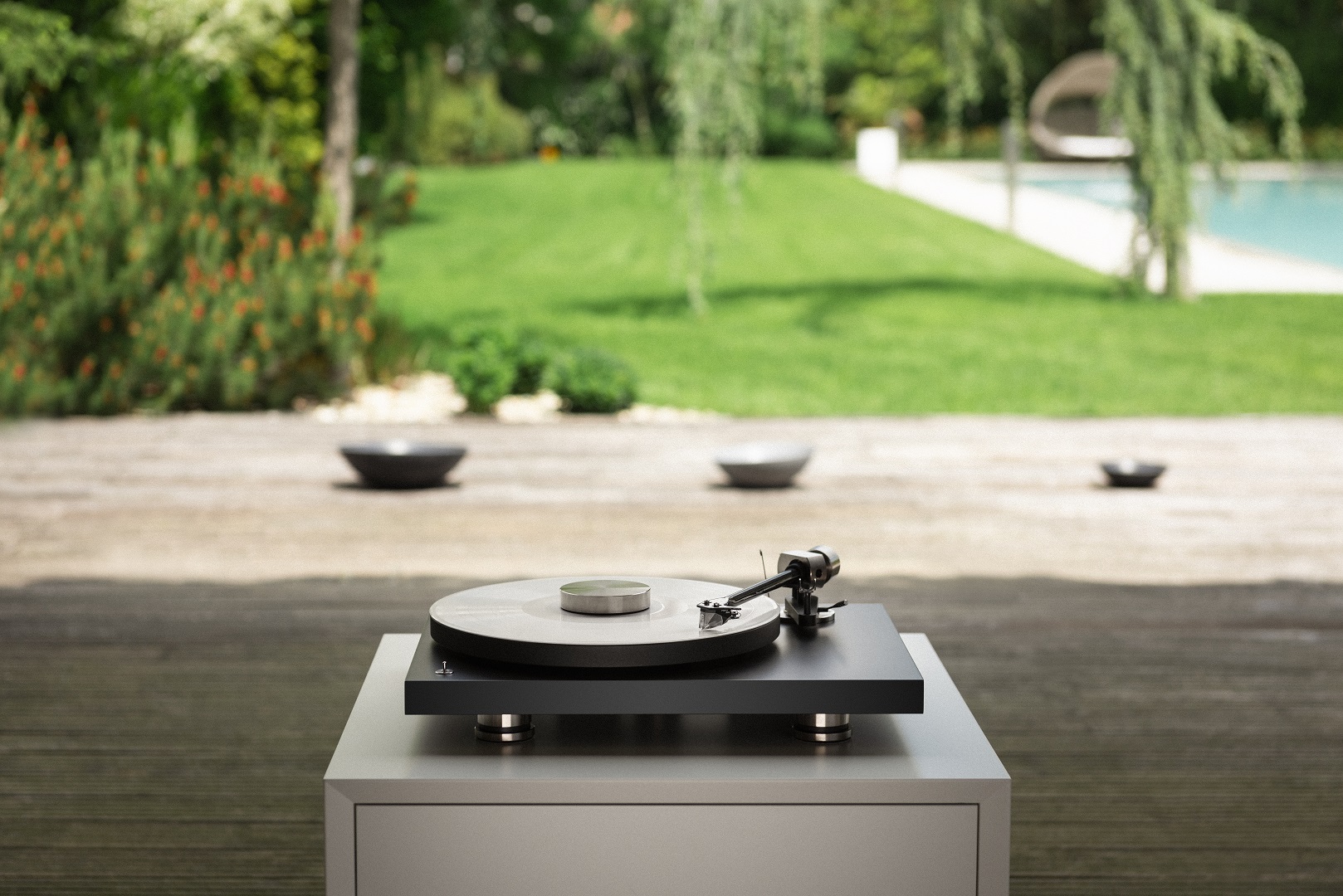 Debut Pro turntable placed in the garden with pool and grass behind