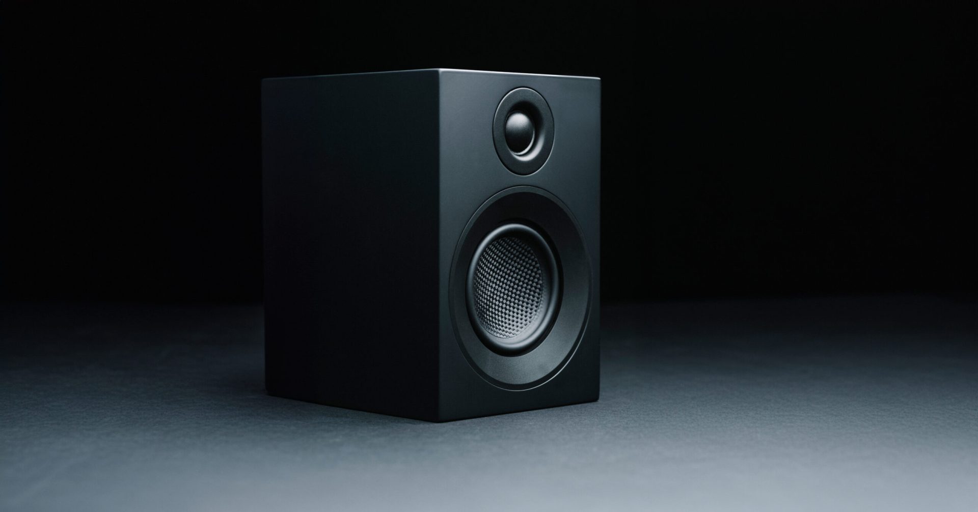 Speaker Box 3e Carbon Satin Black Detail Sideways Standing on white ground with black background